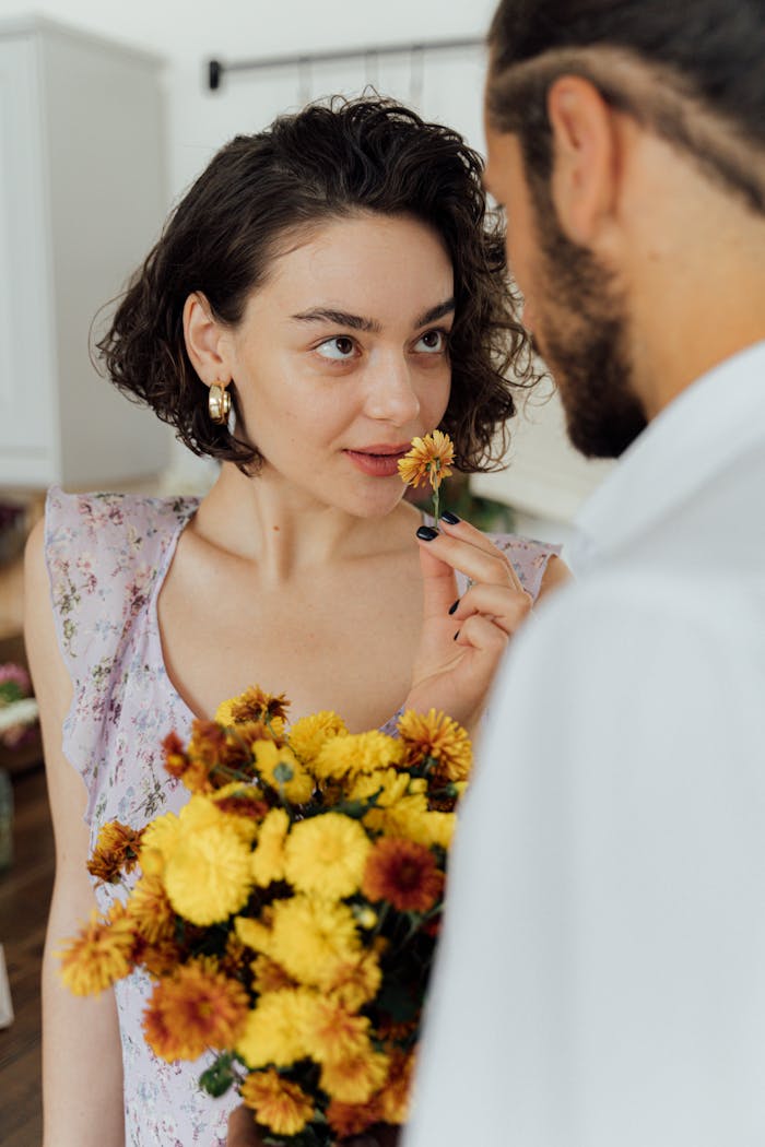 Man Holding Bouquet of Flowers in Front of a Woman